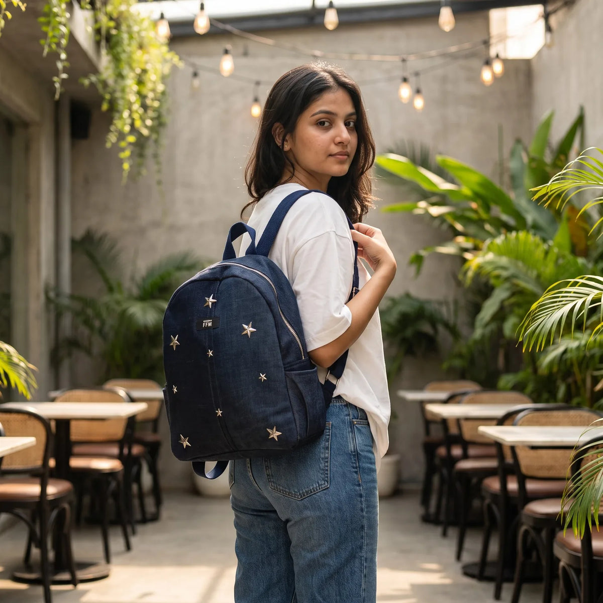 Aura Stride Medium backpack carried by a model, made from upcycled jeans