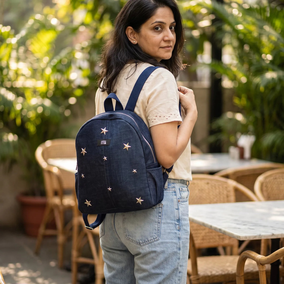 Aura Stride Medium backpack carried by a model, made from upcycled jeans